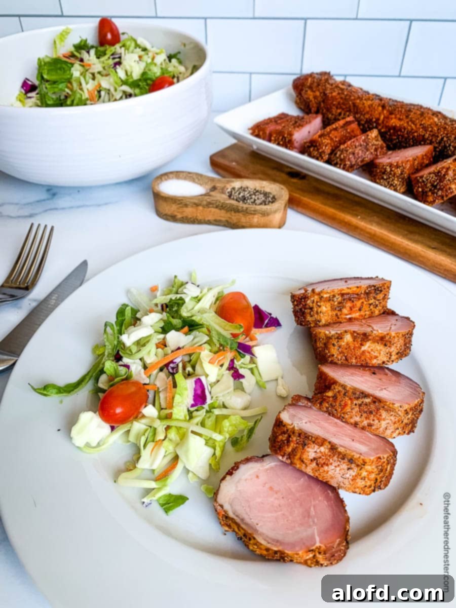 Sun-Kissed Suppers Made Simple 14 Slices of perfectly smoked pork tenderloin, elegantly plated with a fresh salad, and a larger platter of tenderloin in the background.