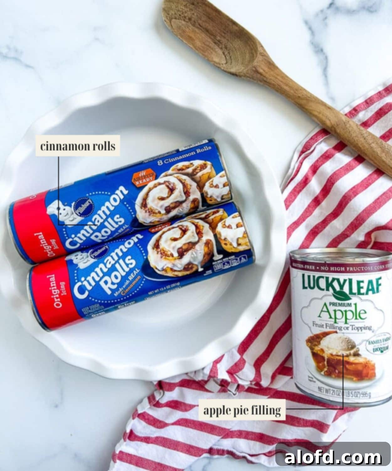 Labeled ingredient image for making cinnamon rolls with apple filling, featuring a can of cinnamon rolls and a can of apple pie filling.