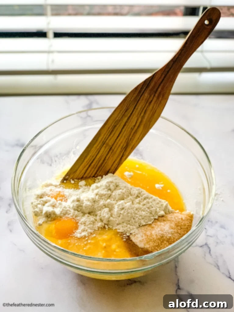 Bisquick Cornbread No Cornmeal Needed 4 Mixing ingredients in a bowl for cornbread without cornmeal, showing a smooth, thick batter.