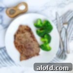 Blackstone Dinners Made Simple 8 Steaks sizzling on a Blackstone griddle, with a white plate, silverware, napkin, and seasonings nearby.