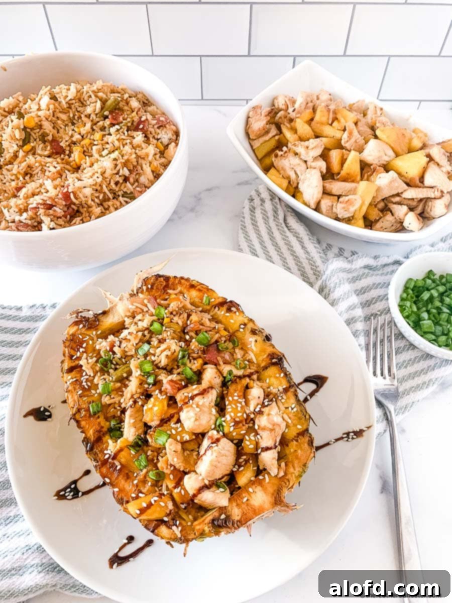 chicken teriyaki pineapple bowl with teriyaki glaze placed on a white plate with cloth, pineapple chicken, fried rice, and onion chives all placed in a bowl at the background.