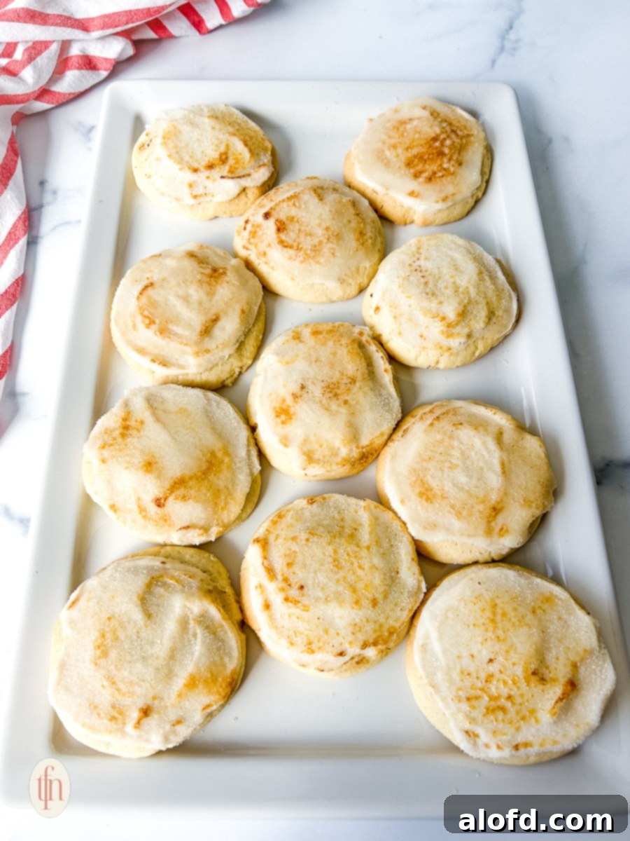 Frosted crème brûlée cookies arranged neatly on a white plate.