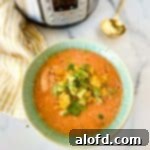 a square photo of a green bowl with Instant Pot Chicken Tortilla Soup with a striped yellow cloth, Instant Pot, and a golden spoon at the side.