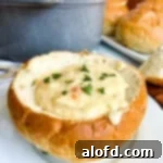 San Francisco Clam Chowder in a bread bowl on a white plate.