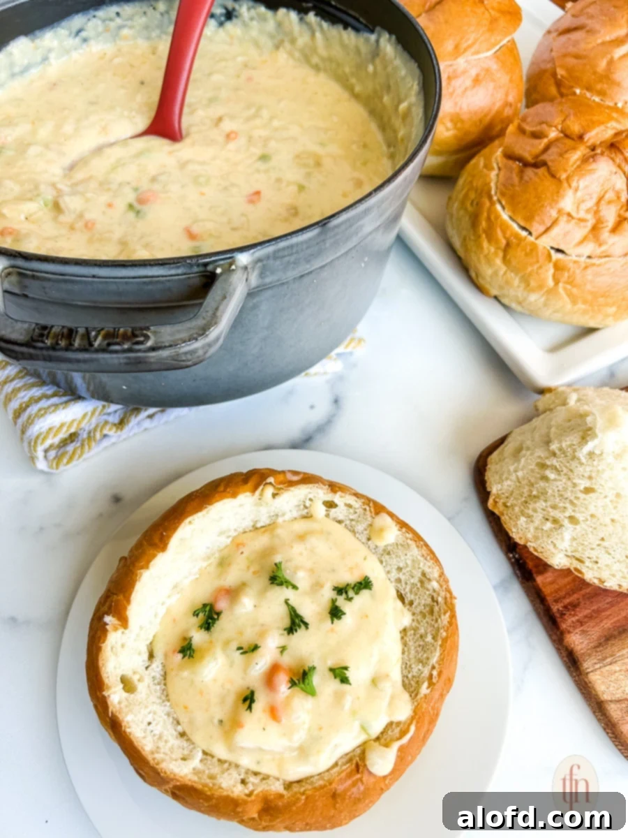San Francisco Clam Chowder in a bread bowl on a white plate.