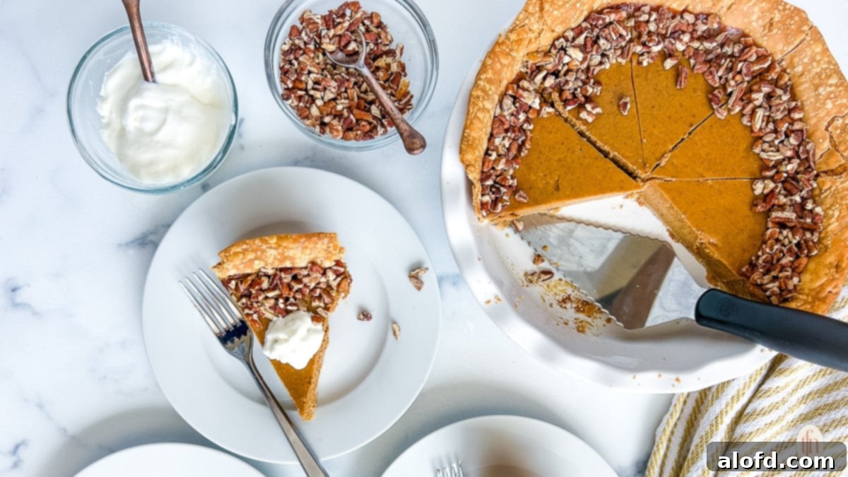 A piece of pumpkin custard pie next to an pie with a slice cut out.