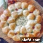 a close up photo of baked camembert and bread ring on top of a wooden board.