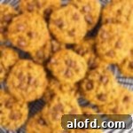 Freshly baked pumpkin oatmeal chocolate chip cookies cooling on a wire rack.