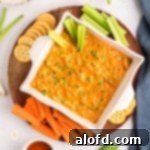 Game Day Grub 16 A serving of buffalo dip on a platter with crackers and vegetables.