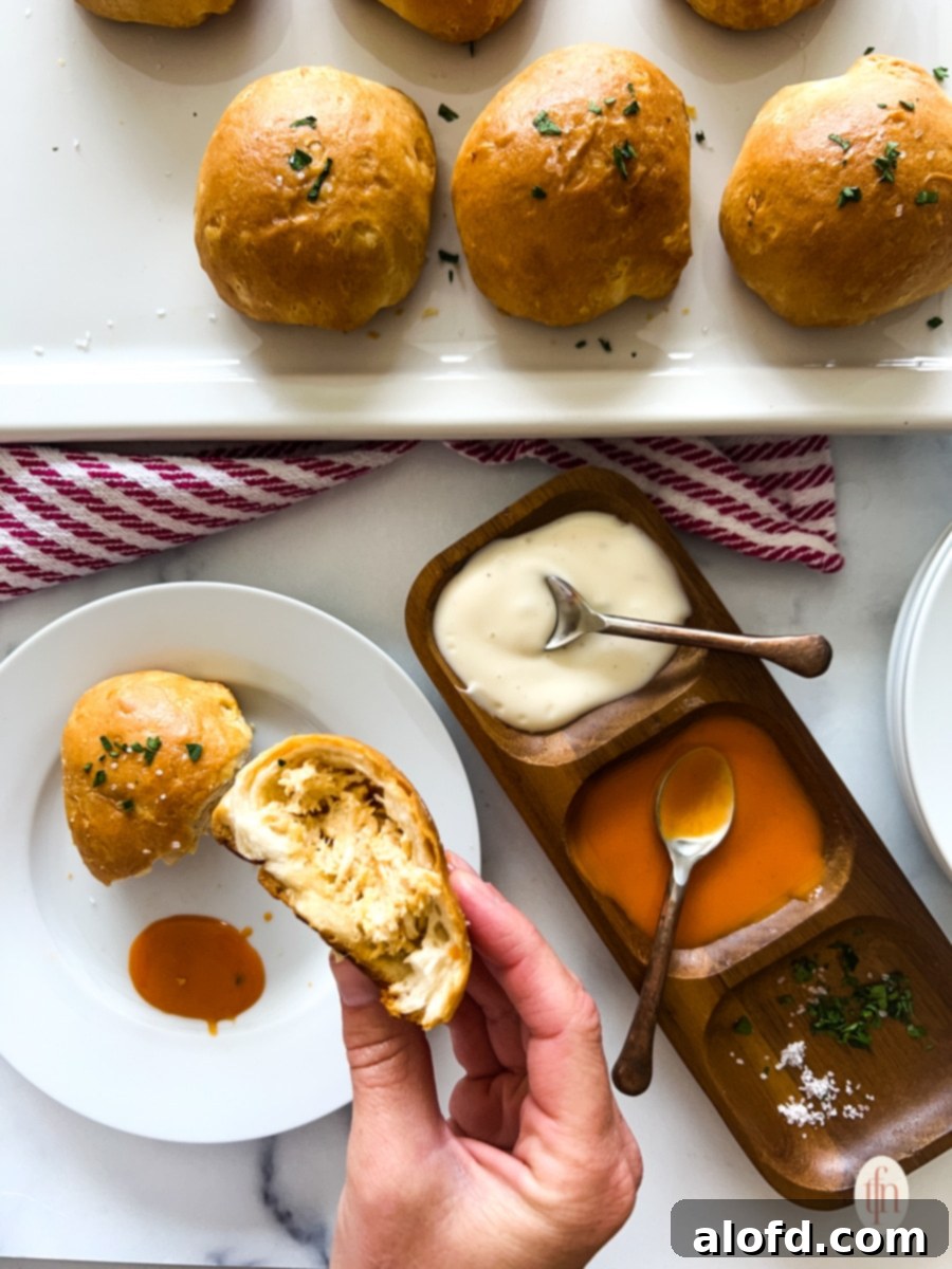 Game Day Grub 5 Holding one half of a chicken ball over a plate and dish filled with condiments.