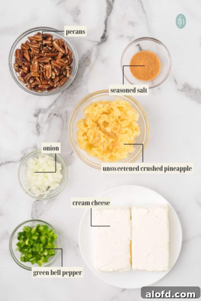 Overhead shot of all the ingredients needed to make a pineapple cheese ball laid out on a marble surface. Ingredients include pecans, seasoned salt, crushed pineapple, chopped onion, chopped green bell pepper, and two blocks of cream cheese.