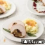 A square-cropped image showcasing two tender slices of stuffed turkey breast, beautifully served on a white plate next to a generous mound of mashed potatoes, elegantly topped with rich gravy and garnished with a fresh sage leaf.