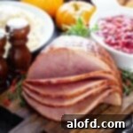Perfectly sliced Crock Pot Dr. Pepper Ham, artfully arranged on a rustic wooden board, ready for serving.