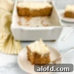A beautifully plated slice of apple cake, with the baking pan gently visible in the background, invitingly ready to be enjoyed.