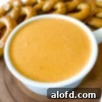 A inviting bowl of Pretzel Cheese Dip, artfully arranged with warm pretzels nearby for dipping.