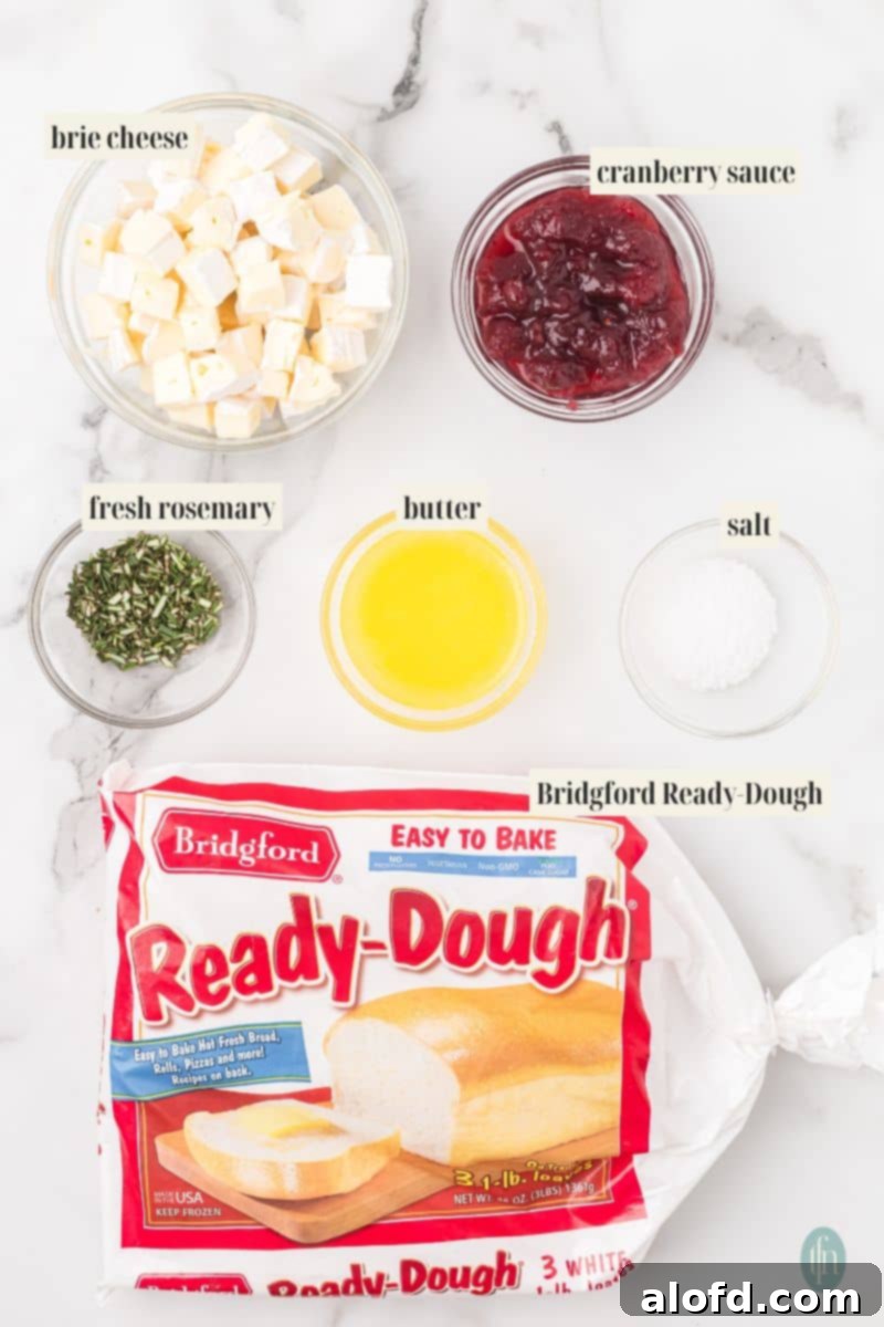 The key ingredients for cheese stuffed dinner rolls: brie cubes, cranberry sauce, chopped rosemary, melted butter, salt, and Bridgford Ready-Dough.