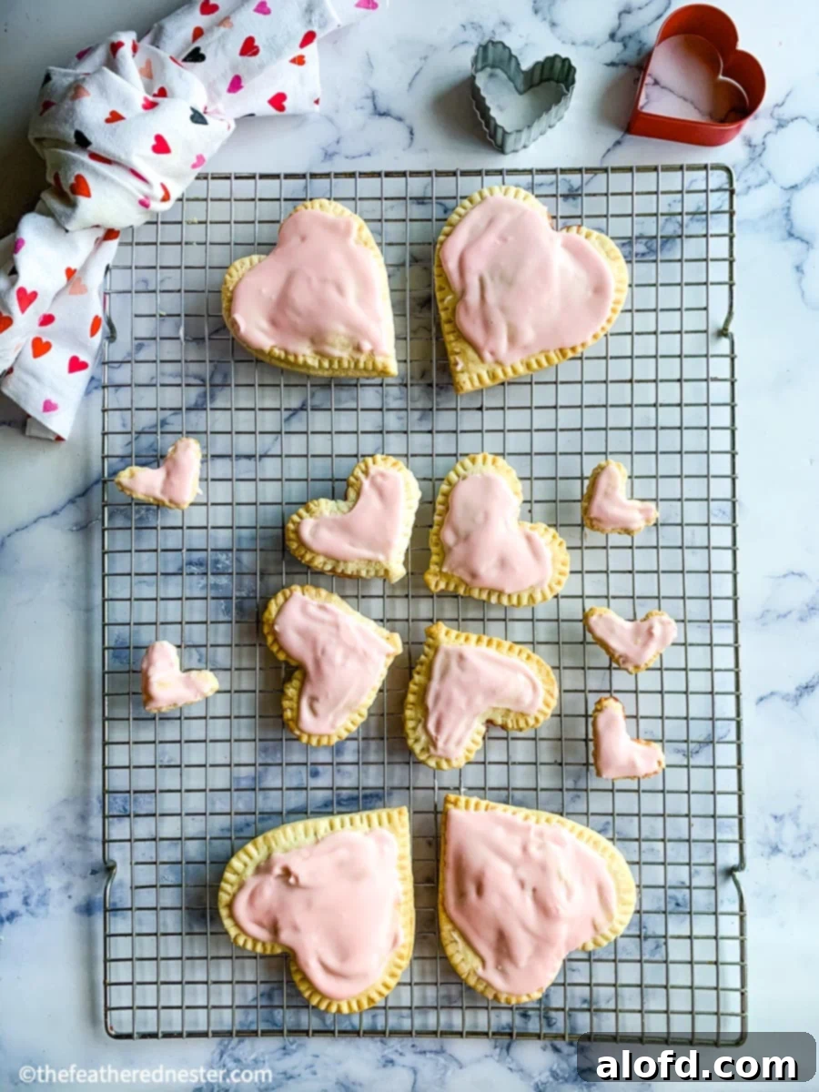 Cupid's Confections 2 Sweet Valentine's Day pop tarts, flaky on the outside and filled with strawberry or cherry jam, arranged on a cooling rack, perfect as snacks or desserts that everyone will LOVE.