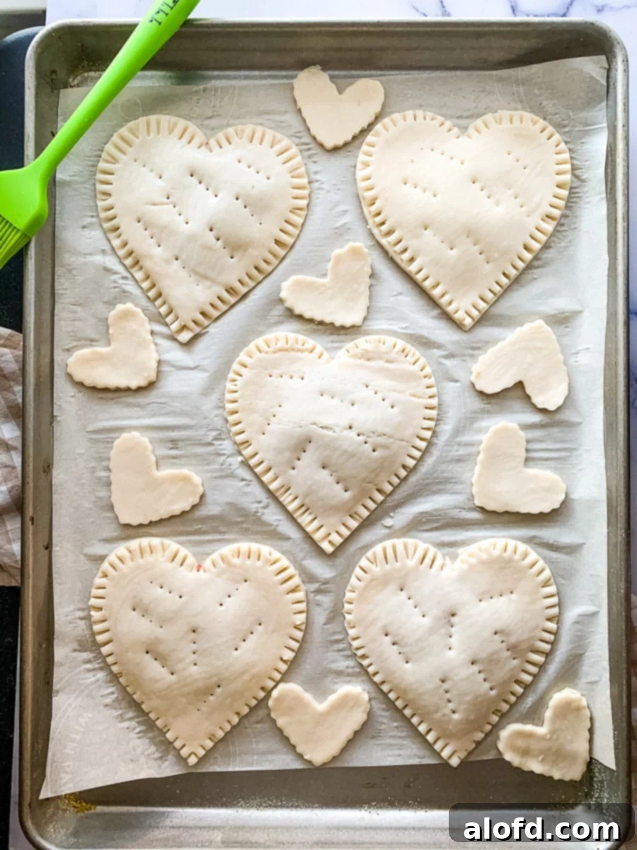 Cupid's Confections 7 Pastry dough in a heart shape on a baking sheet, ready for the next step in making Valentine's Day hand pies.