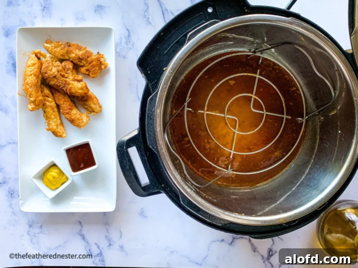 Cooked chicken tenderloins on a platter with dipping sauces, next to an Instant Pot pressure cooker containing a trivet.