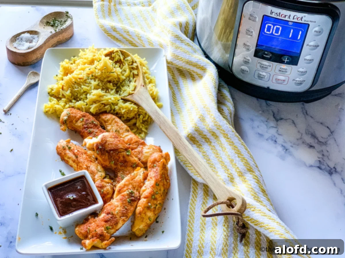 A vibrant platter of cooked Instant Pot chicken tenderloin strips, artfully arranged with fluffy rice and individual bowls of rich dipping sauces, perfectly complemented by an Instant Pot. This image highlights an easy, delicious, and versatile meal.