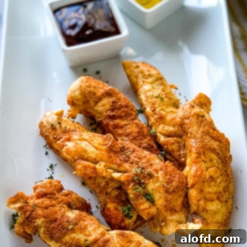 A plate of Instant Pot Chicken Tenders served with honey mustard and barbecue dipping sauces, showcasing a perfect quick meal.