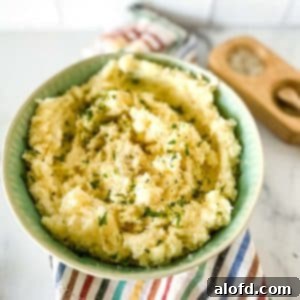 Dreamy Instant Pot Red Potato Mash 11 a green bowl full of potatoes ready to serve.