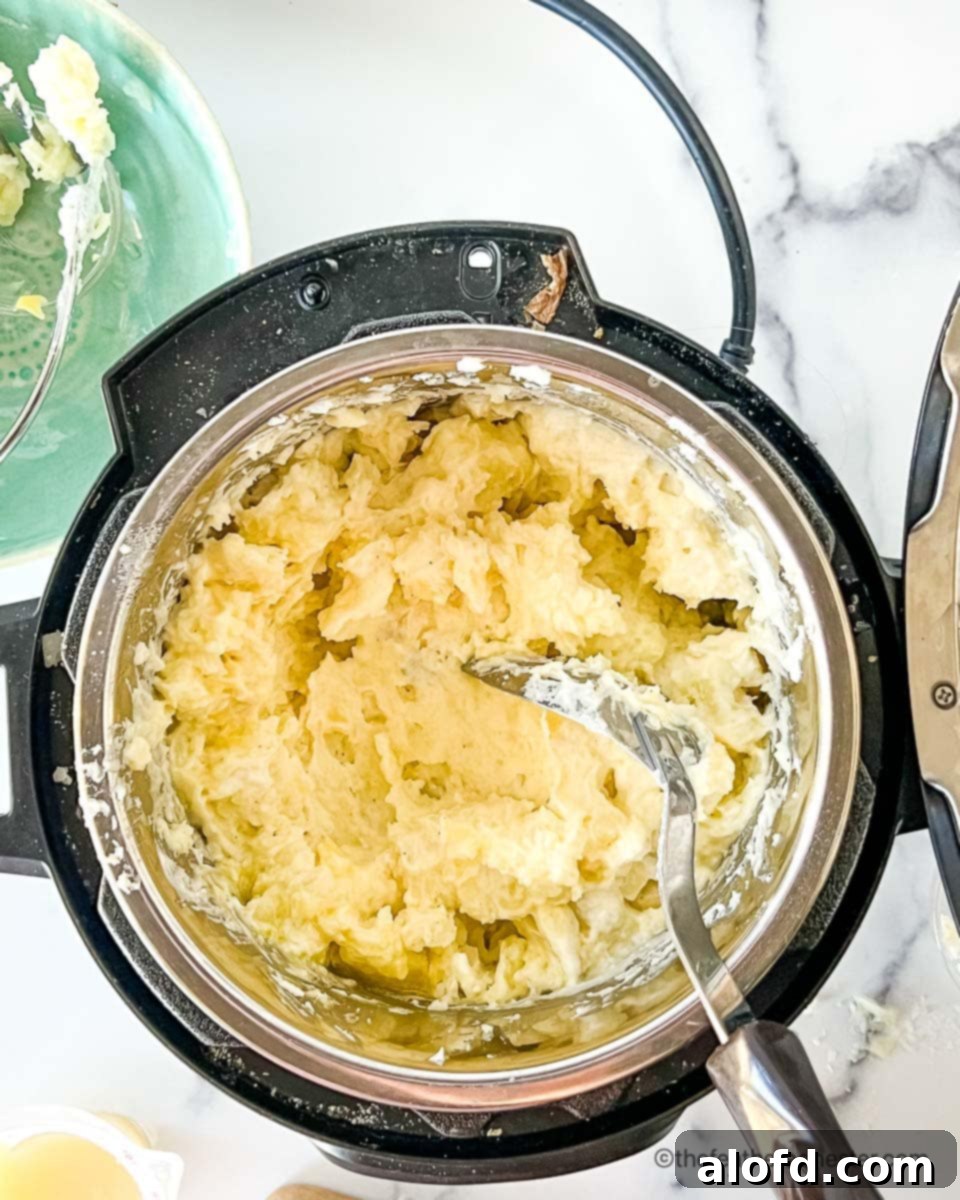 Dreamy Instant Pot Red Potato Mash 7 Stirring seasonings into Instant Pot red mashed potatoes.