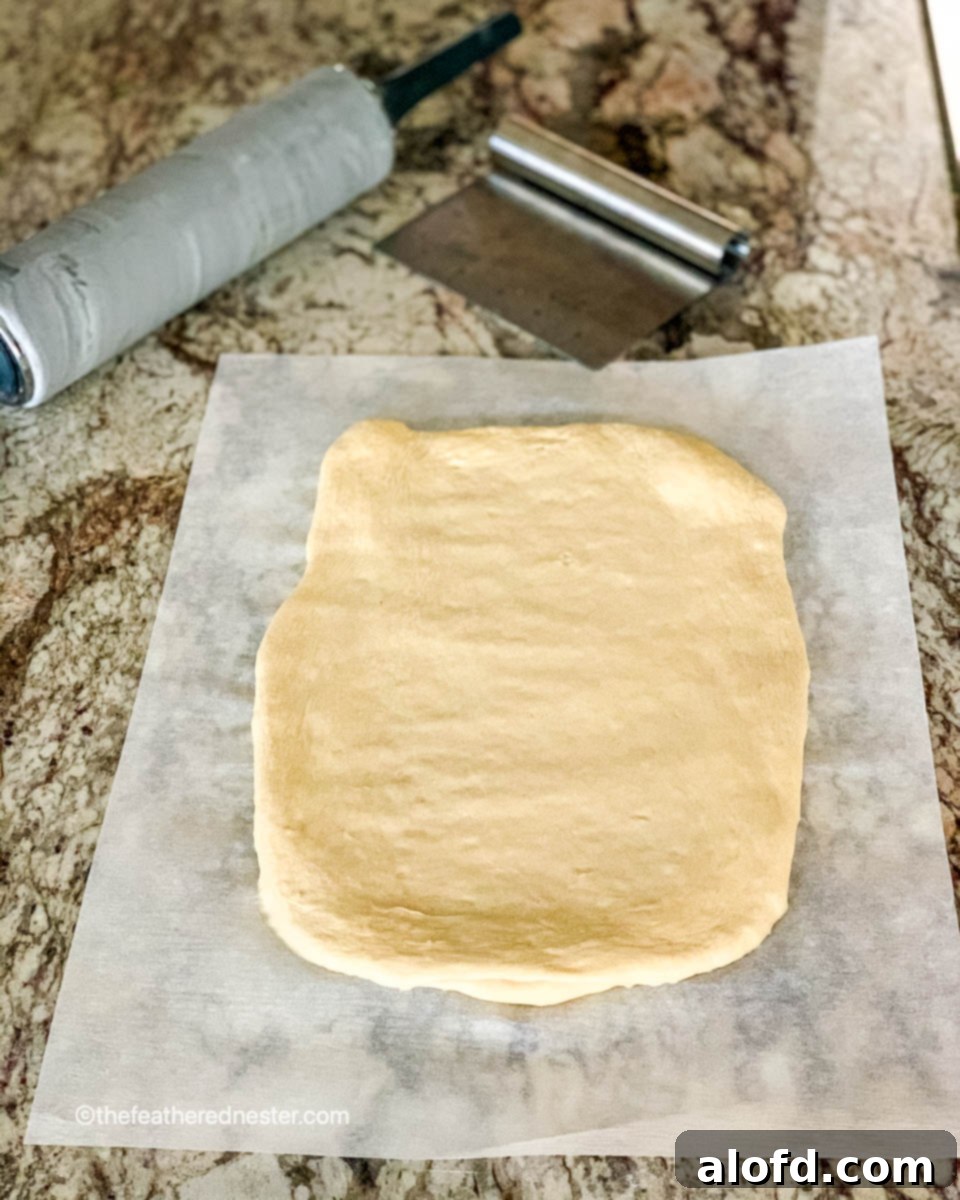Rolling out the dough into a rectangular shape on a lightly floured surface.