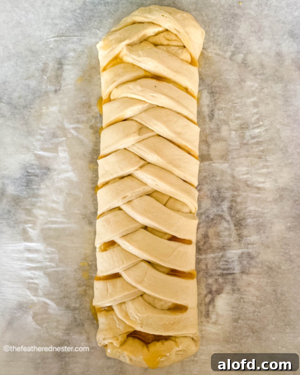 Baked braided lemon bread, golden brown and puffed, cooling on a wire rack.