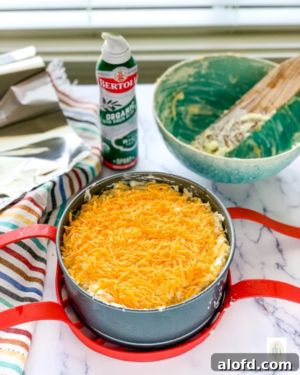 Creamy Instant Pot Cheesy Potatoes 5 Shredded cheddar cheese on top of an unbaked casserole.