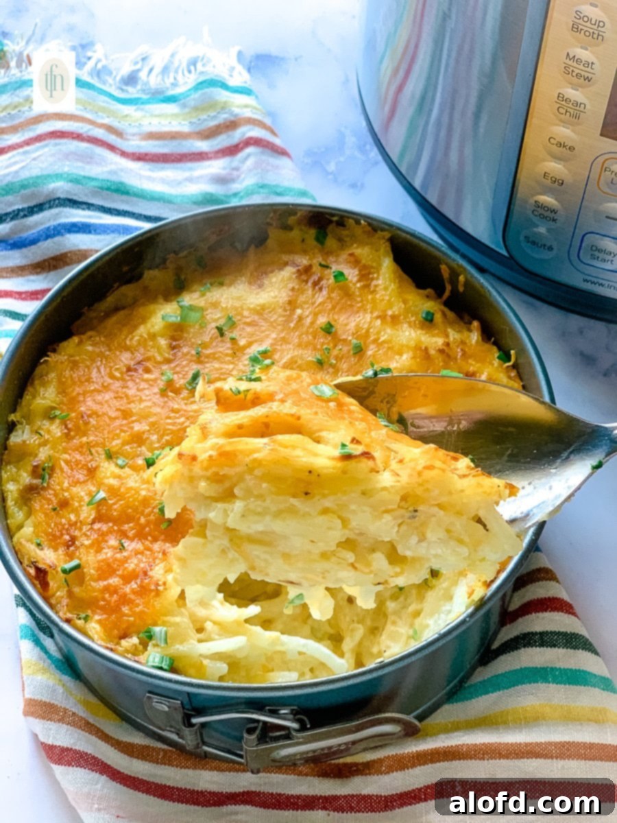 Creamy Instant Pot Cheesy Potatoes 8 Scoopful of cheesy hashbrowns on a large serving spoon.
