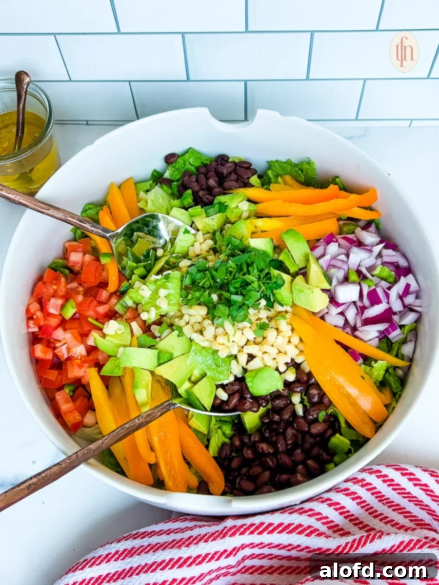 Large bowl of Tex Mex cowboy salad with crisp veggies, beans, and avocado
