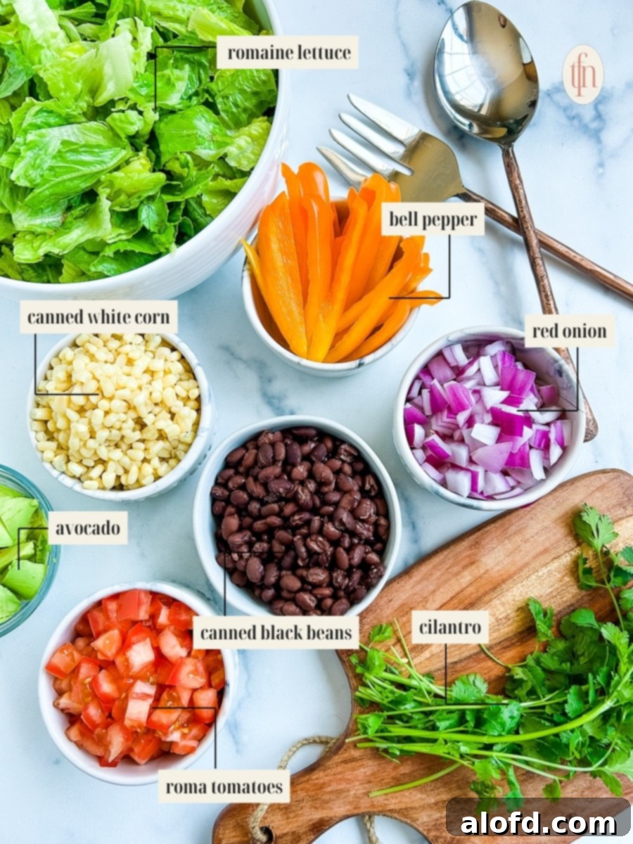 Labeled ingredients for a Tex Mex cowboy salad recipe, including fresh vegetables, beans, and herbs.