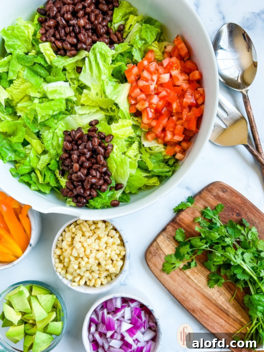 Assembling a summer side dish in a white salad bowl, showing various fresh ingredients being combined.