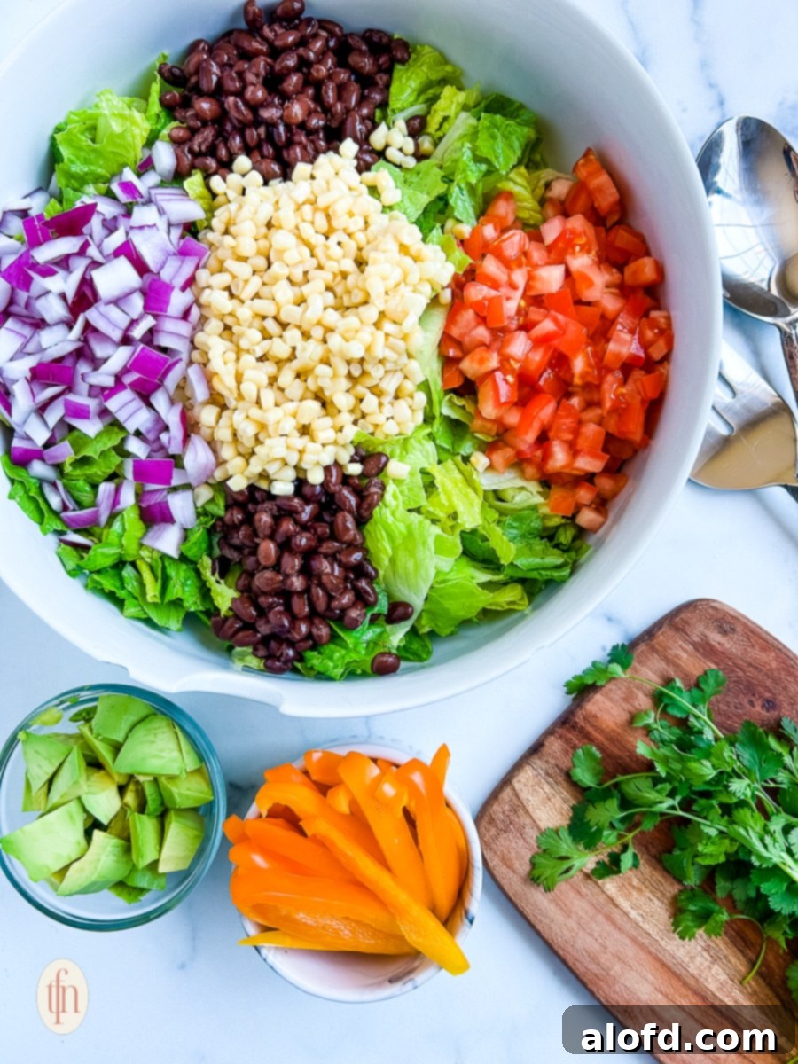 Chopped tomatoes and red onion layered on top of crisp romaine lettuce with black beans and corn.