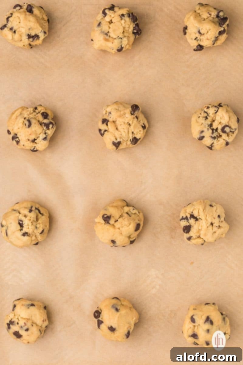 Balls of cookie dough on top of a parchment paper.
