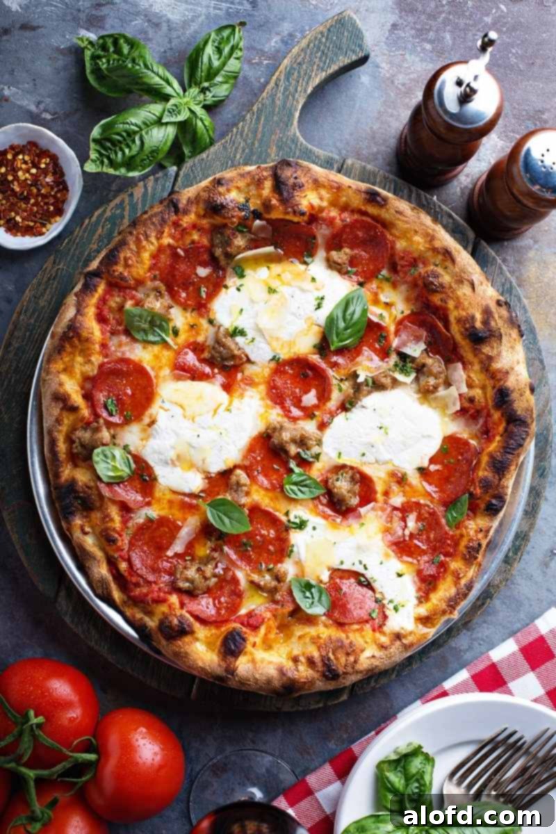 Delicious baked pepperoni pizza garnished with fresh basil, aromatic spices, and ripe tomatoes, ready to be served.