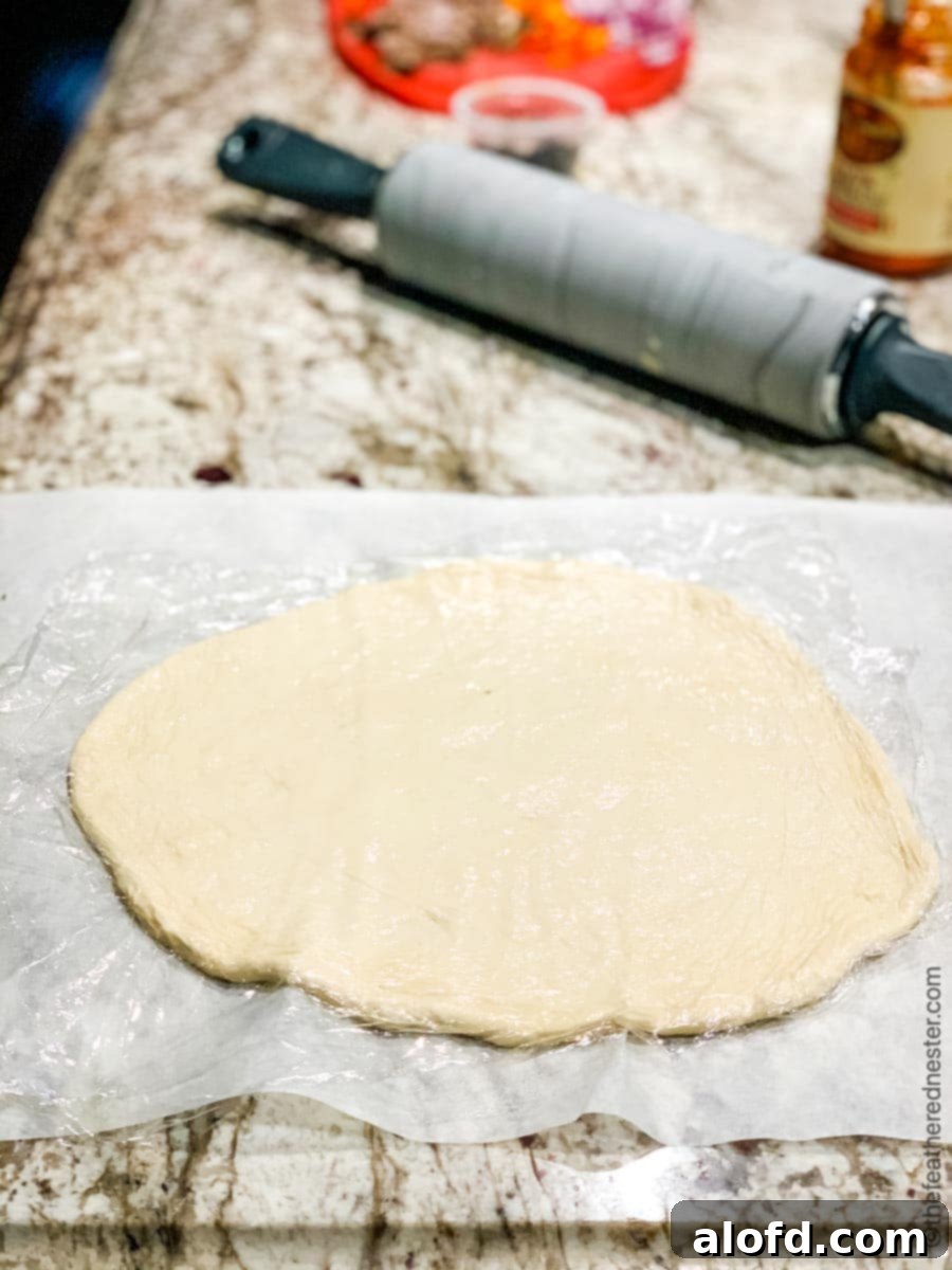 Perfectly rolled out pizza dough spread on a clean kitchen counter, ready for toppings.