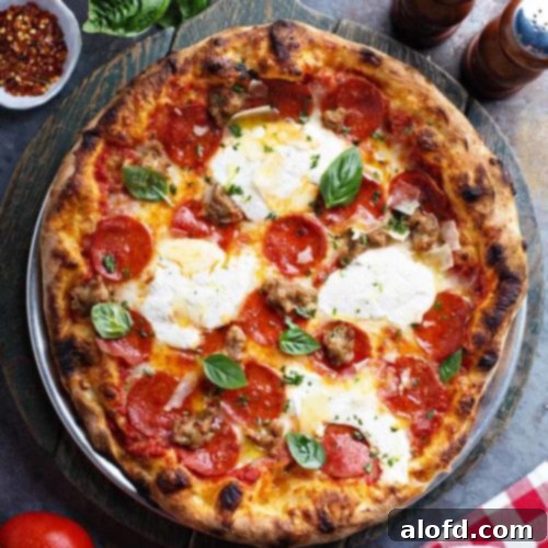 A delicious pizza crust adorned with fresh salad greens, aromatic spices, and vibrant tomatoes, showcasing the versatility of frozen dough.