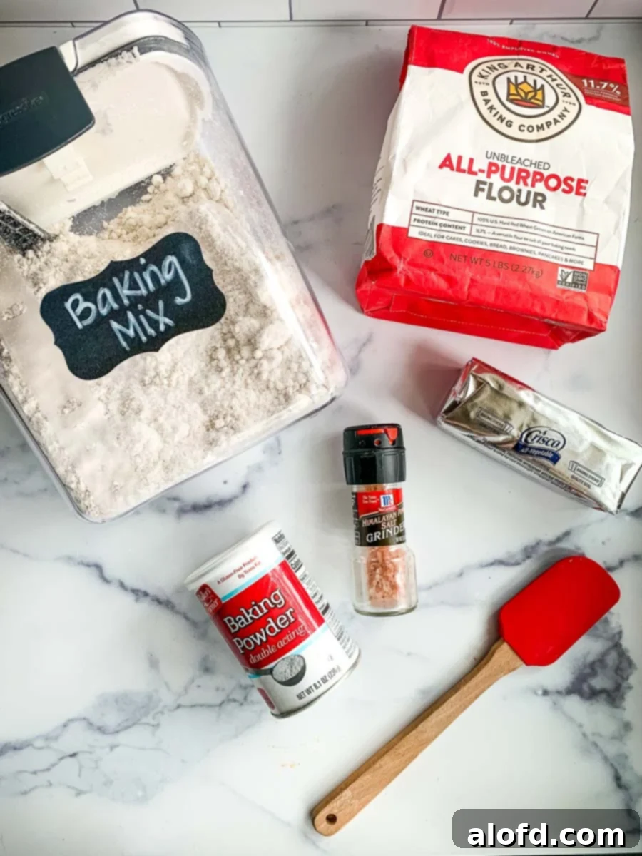 Simple Homemade Bisquick Mix 6 A flat lay photograph of the individual ingredients for homemade Bisquick mix: flour, shortening, baking powder, and salt, highlighting their simplicity.
