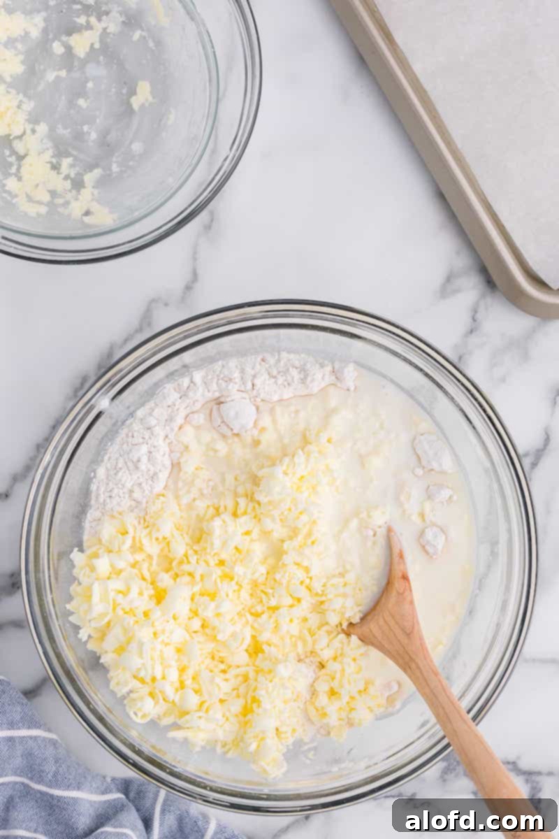 Homestyle Buttermilk Biscuits 5 Whisking grated butter, self-rising flour, and buttermilk together in a bowl for 3-ingredient buttermilk biscuits.