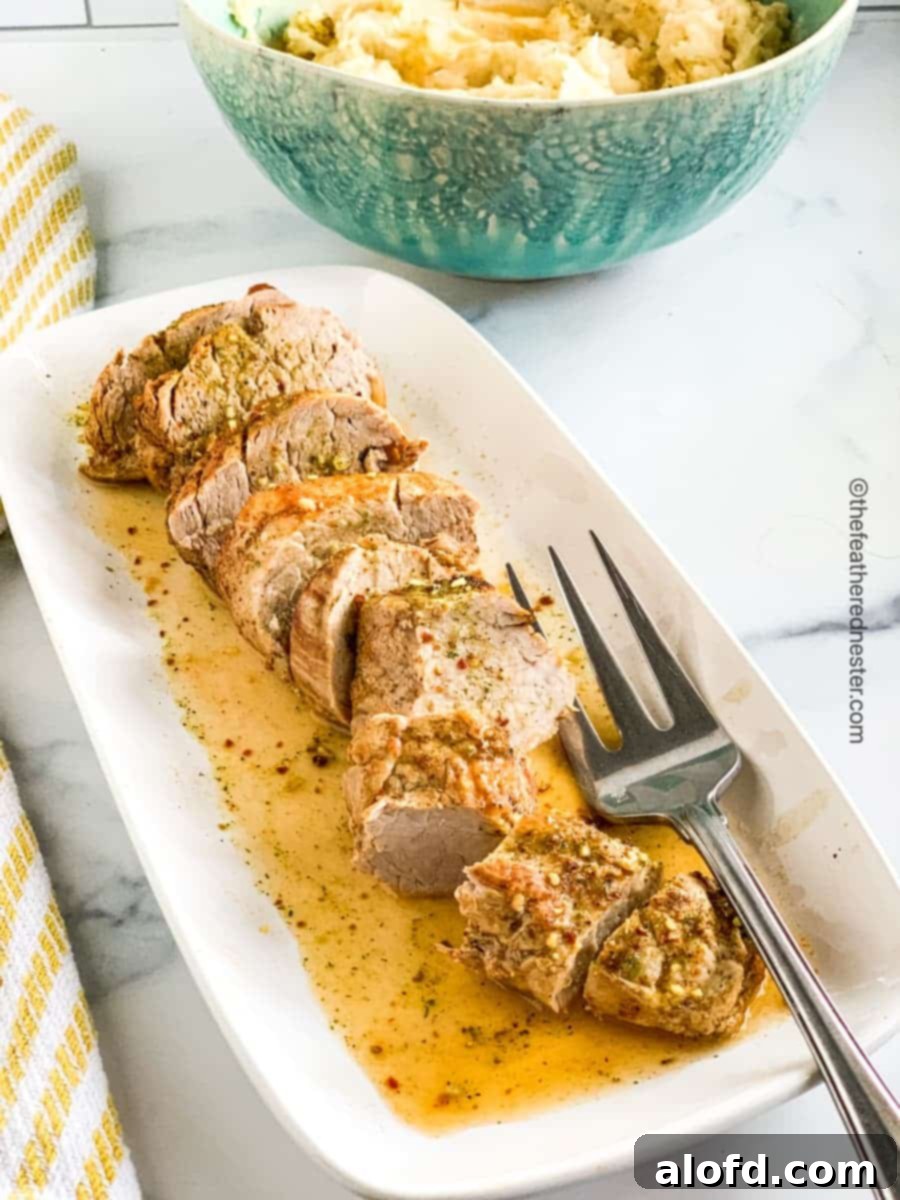 A platter of instant pot pork tenderloin sliced and ready to serve with a side of gravy.