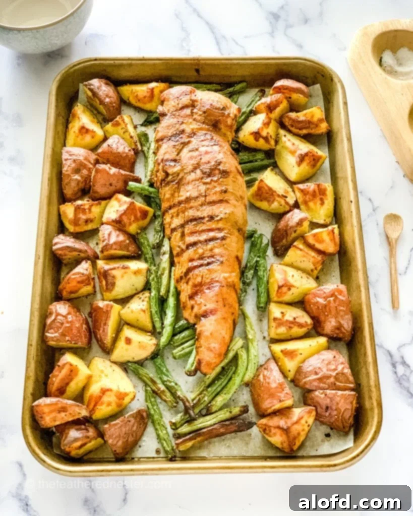 Perfectly cooked Sheet Pan Pork Tenderloin with a medley of autumn vegetables.