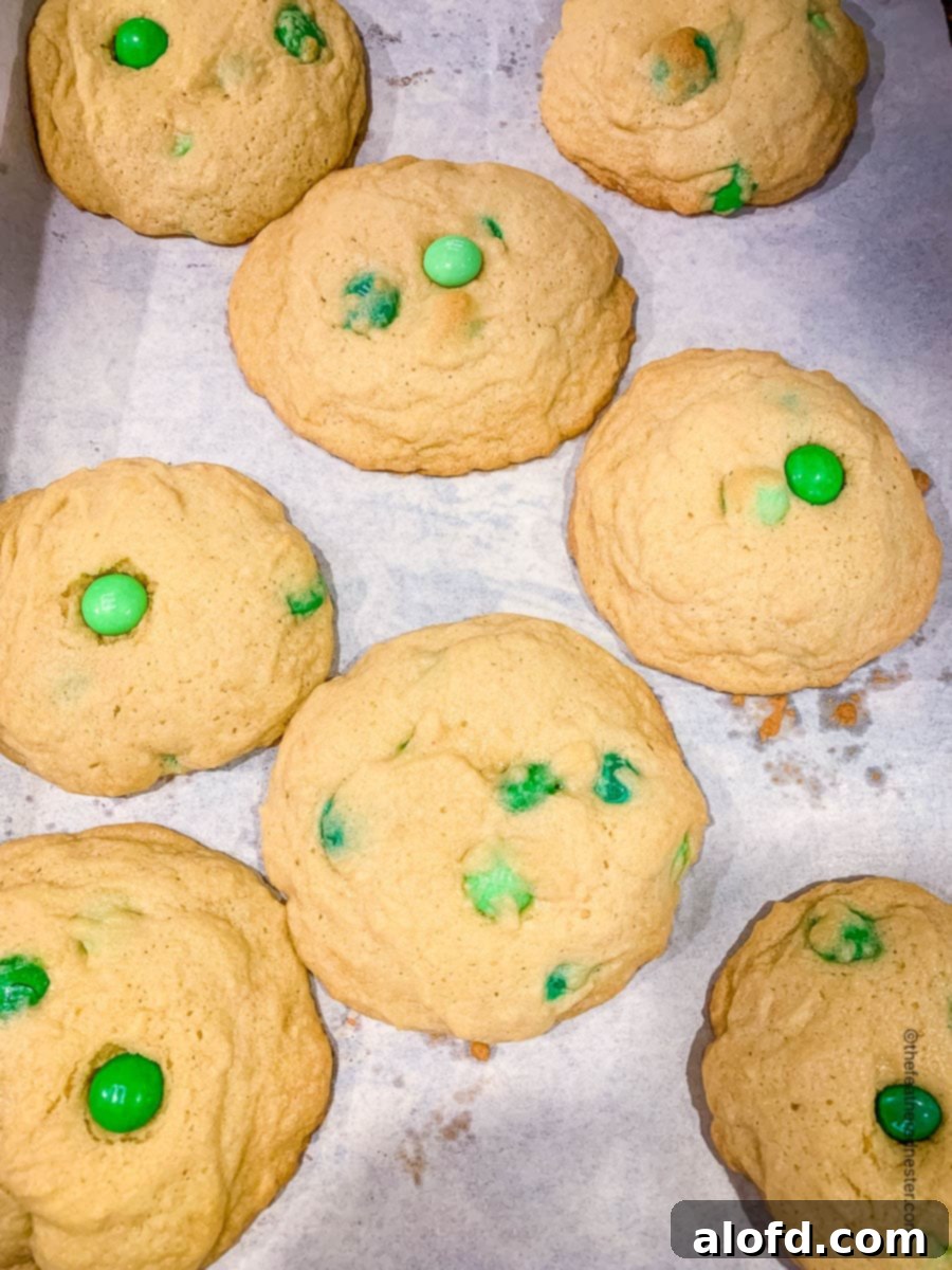 Refreshing Mint Chocolate Indulgence 7 A baking sheet filled with freshly baked mint M&M cookies, just out of the oven, with golden edges and vibrant candies.