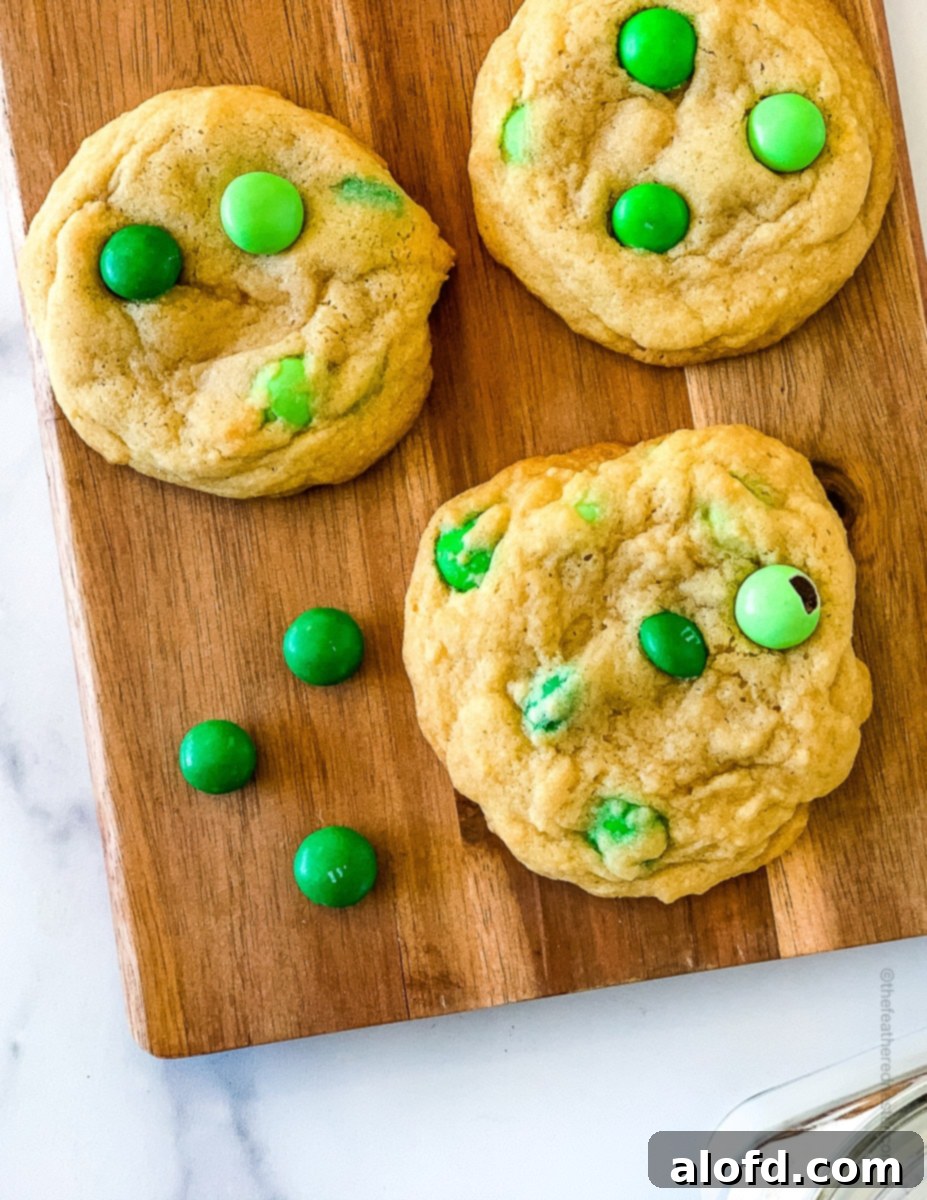 Refreshing Mint Chocolate Indulgence 9 Green mint M&M Christmas cookies beautifully arranged on a rustic wooden serving board, showcasing their vibrant colors and festive appeal.