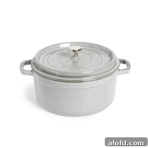 A vibrant red cast iron round Dutch oven, ready for baking or stewing. This durable and versatile cookware is an essential tool for any home chef, perfect for everything from sourdough bread to hearty stews.