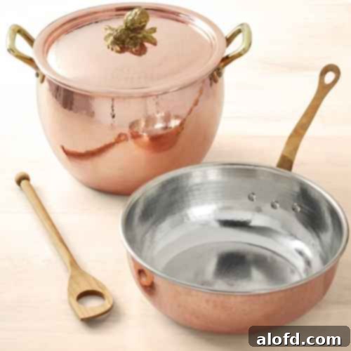 A stunning set of Ruffoni Historia hammered copper cookware, showcasing pots and pans with intricate details and gleaming surfaces. This exquisite collection represents the pinnacle of culinary artistry and functionality.