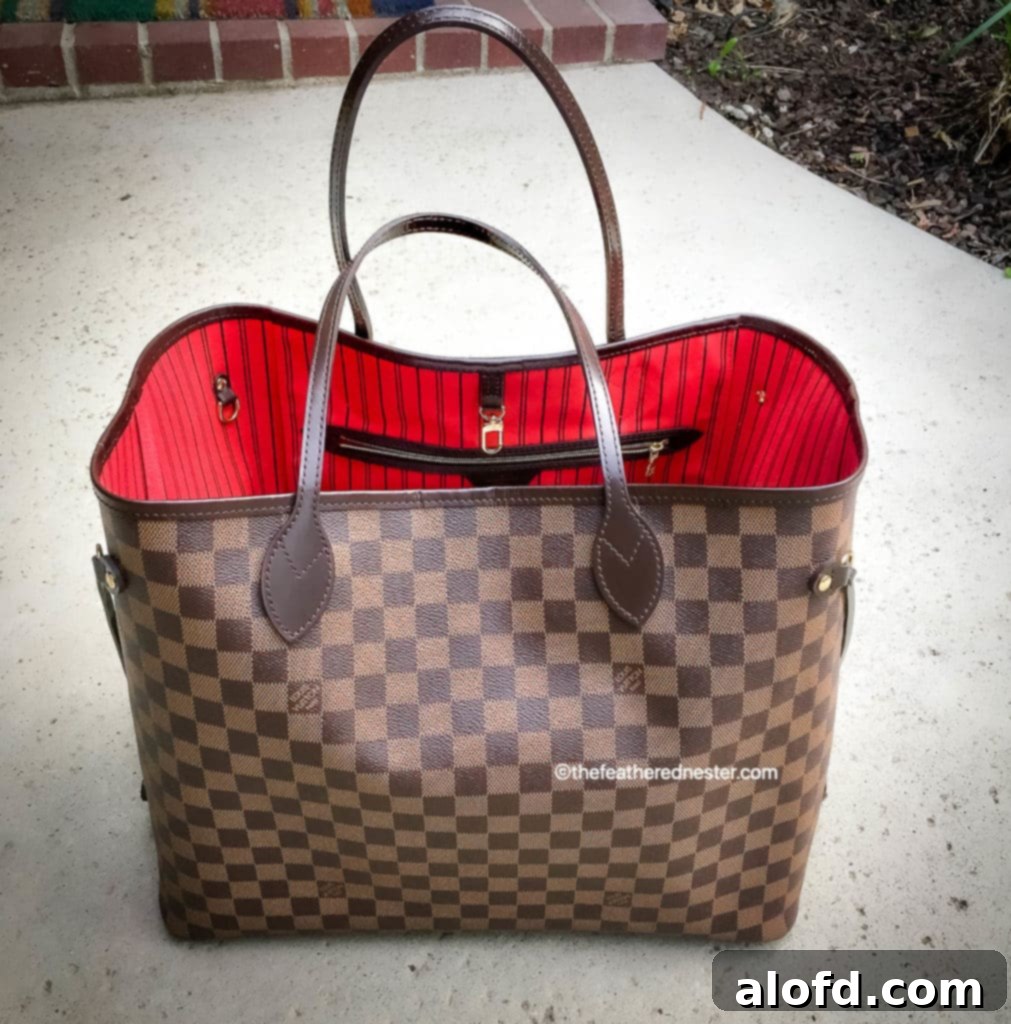 My Unfiltered Review of the Louis Vuitton Neverfull 2 A stunning Louis Vuitton Neverfull tote bag with its vibrant cerise interior lining, showcasing the classic Damier Ebene canvas. Perfect for travel or everyday luxury.