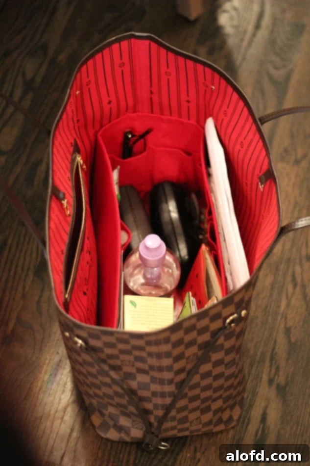 My Unfiltered Review of the Louis Vuitton Neverfull 12 The organized interior of a Louis Vuitton tote bag, packed and ready for travel, featuring essentials neatly arranged.