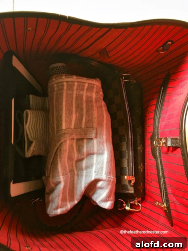 My Unfiltered Review of the Louis Vuitton Neverfull 6 The spacious cerise-lined interior of a Louis Vuitton Neverfull GM tote, ready to be packed for a trip.